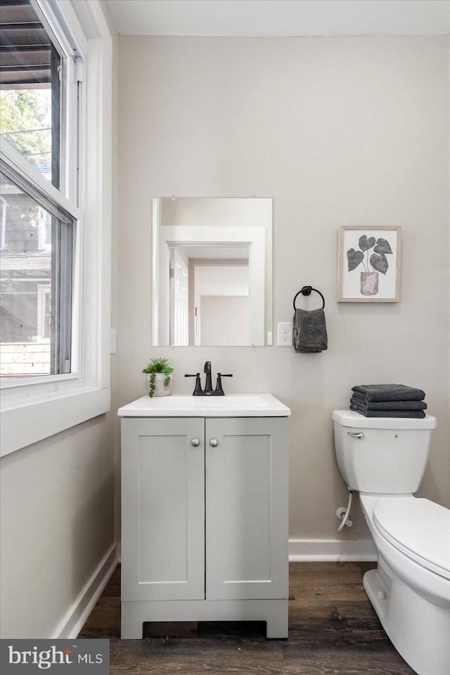 bathroom with vanity, hardwood / wood-style flooring, and toilet