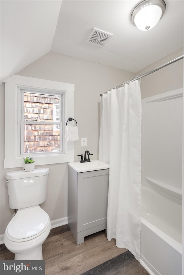 full bathroom featuring lofted ceiling, shower / bath combination with curtain, hardwood / wood-style flooring, toilet, and vanity