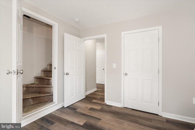 unfurnished bedroom featuring dark wood-type flooring and a closet