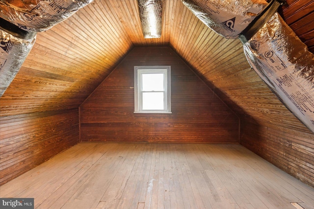 additional living space featuring hardwood / wood-style floors, lofted ceiling, wooden walls, and wooden ceiling