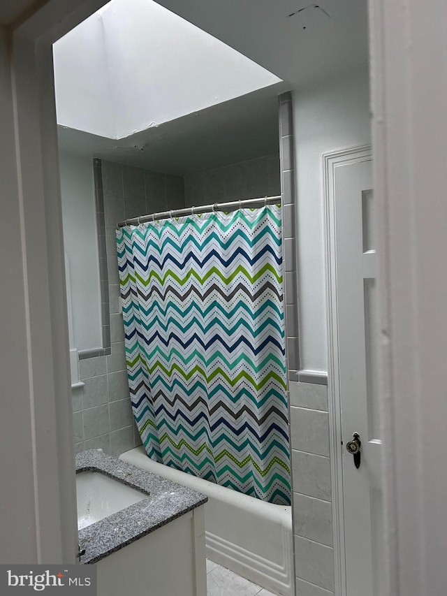 full bathroom featuring shower / tub combo, vanity, and tile walls