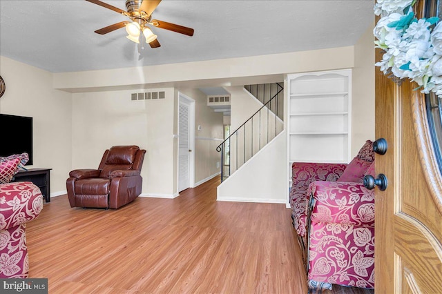 living room featuring hardwood / wood-style floors and ceiling fan