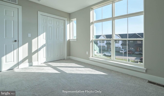 unfurnished room featuring light colored carpet