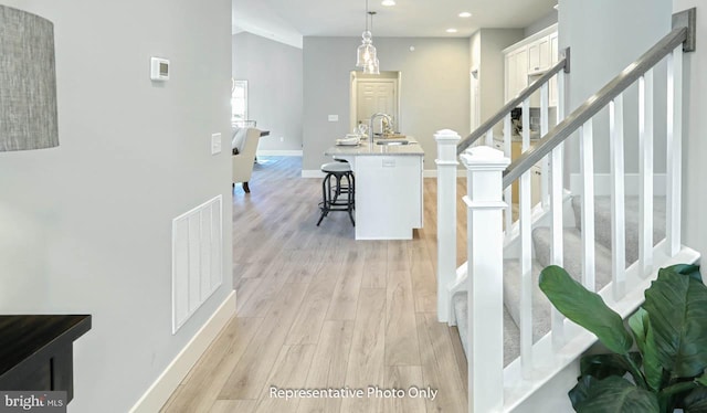 hall featuring sink and light hardwood / wood-style floors