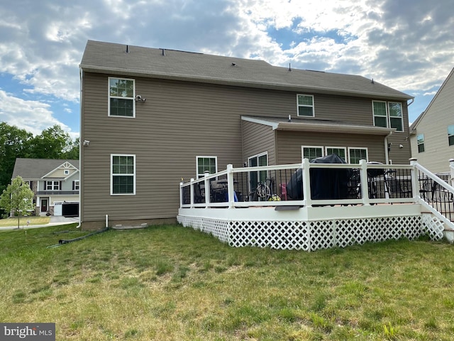 back of house featuring a wooden deck and a lawn