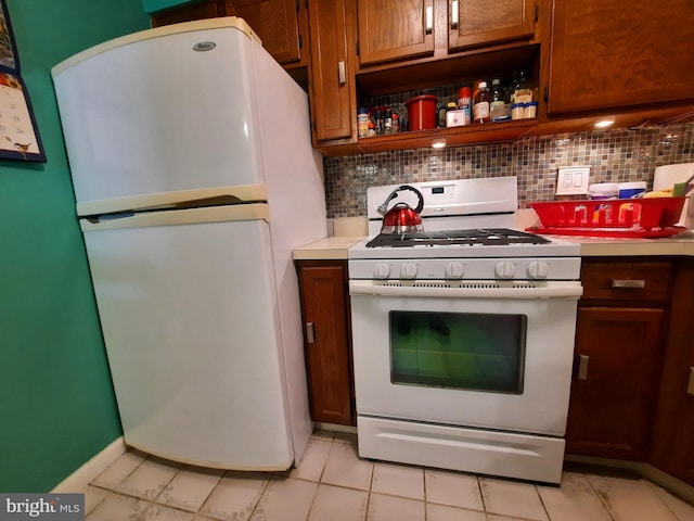 kitchen featuring decorative backsplash, white appliances, and light tile patterned floors