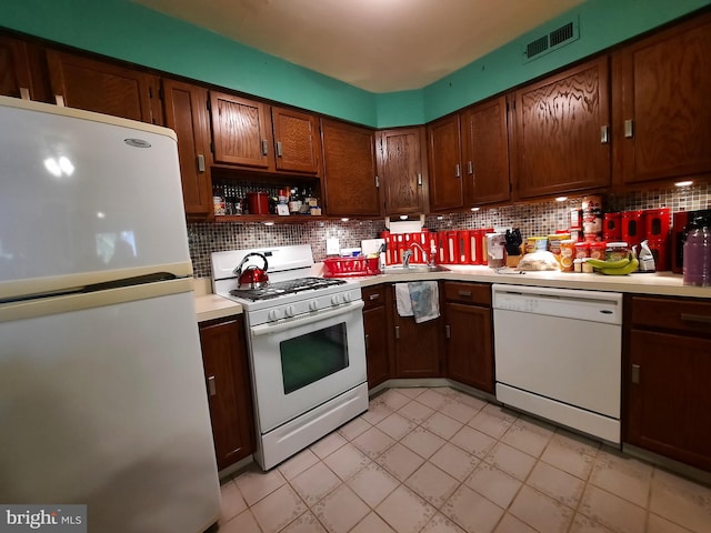 kitchen with sink, decorative backsplash, and white appliances