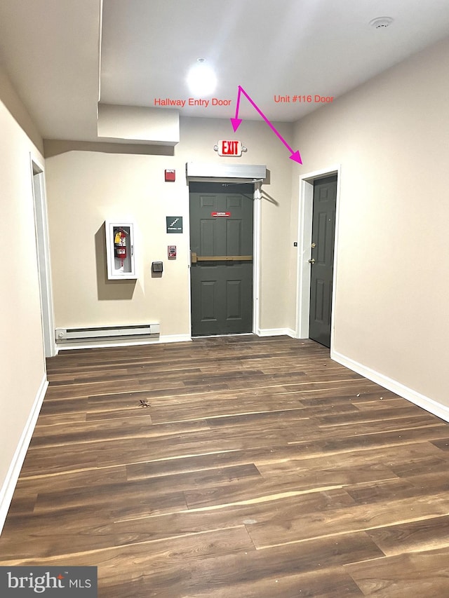 spare room featuring baseboards, a baseboard radiator, and wood finished floors