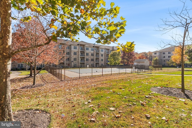 view of property's community with a lawn and fence