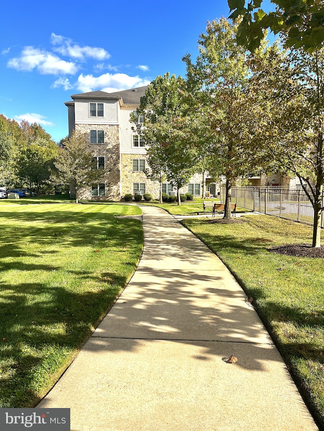view of home's community featuring fence and a lawn