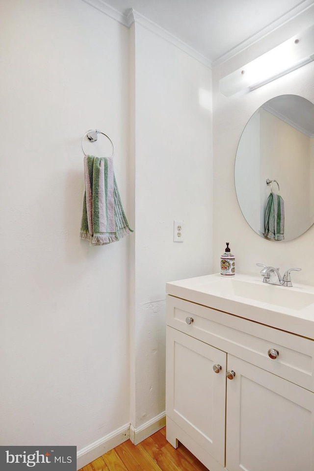 bathroom with vanity, hardwood / wood-style flooring, and ornamental molding