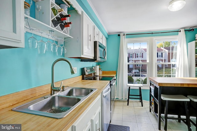 kitchen featuring stainless steel appliances, white cabinetry, crown molding, and sink