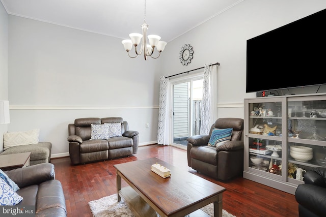 living room featuring crown molding, dark hardwood / wood-style flooring, and an inviting chandelier