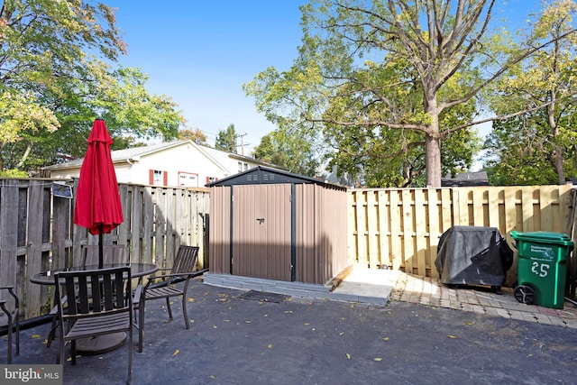 view of patio / terrace featuring a grill and a storage unit