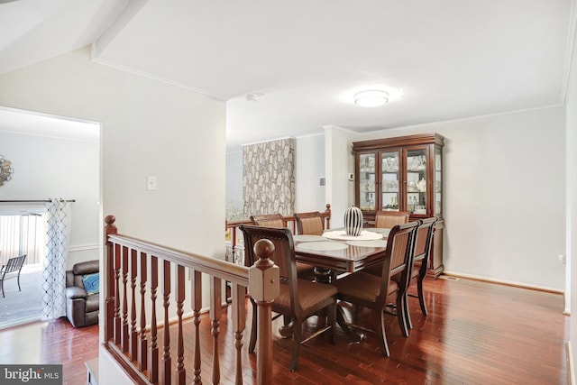 dining room featuring crown molding, lofted ceiling, and hardwood / wood-style flooring