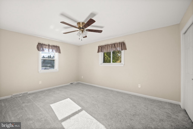 spare room with light carpet, a healthy amount of sunlight, and ceiling fan