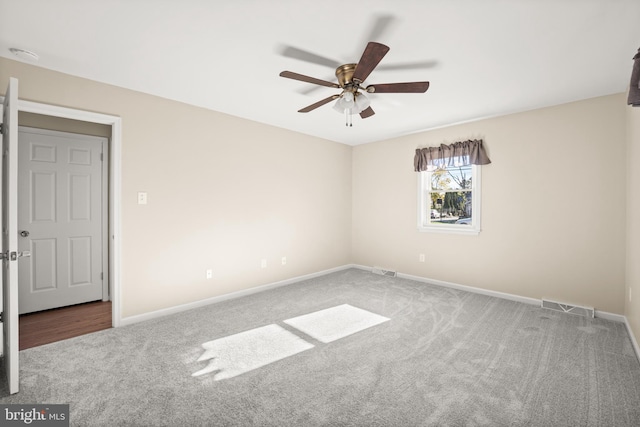 carpeted spare room featuring ceiling fan