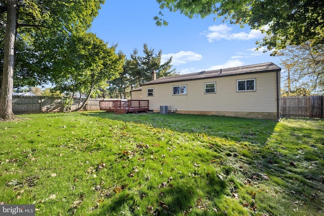 back of house with central AC, a deck, and a yard