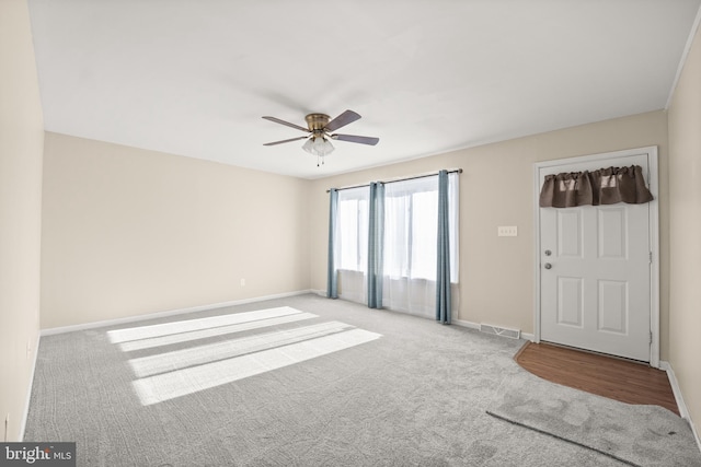 carpeted spare room with ceiling fan