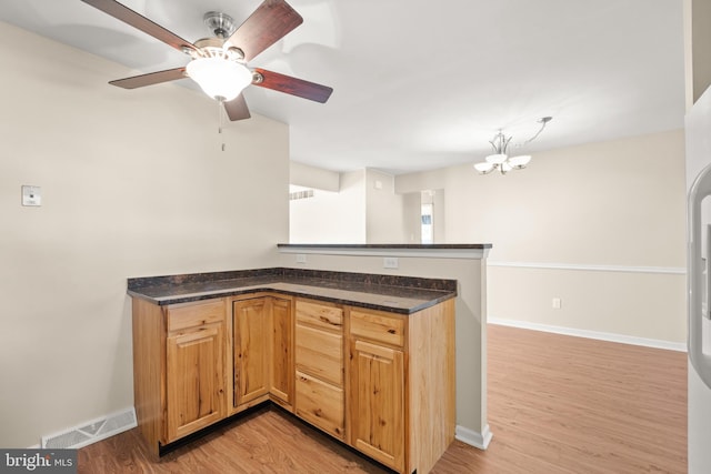 kitchen with light hardwood / wood-style flooring and ceiling fan with notable chandelier