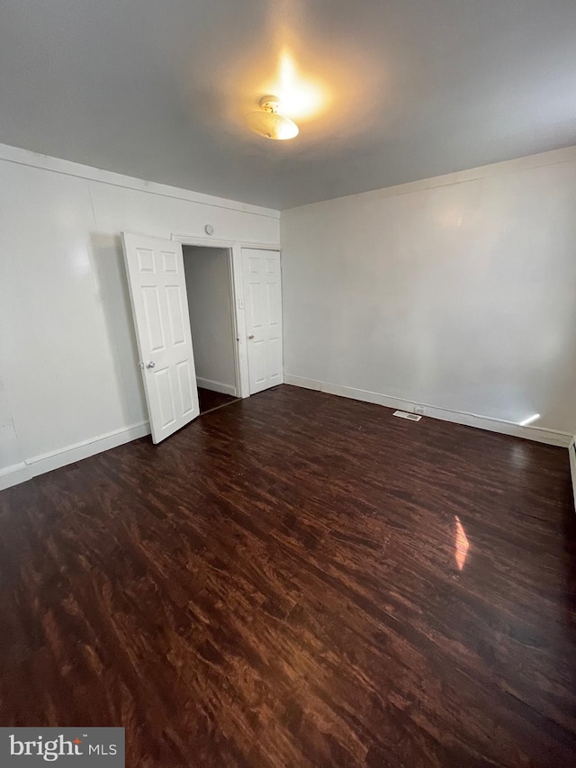 unfurnished room featuring dark wood-type flooring