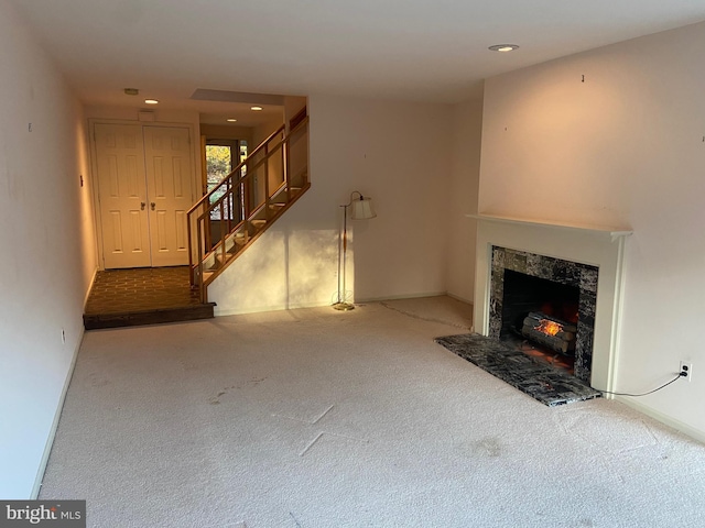 unfurnished living room featuring carpet flooring and a premium fireplace