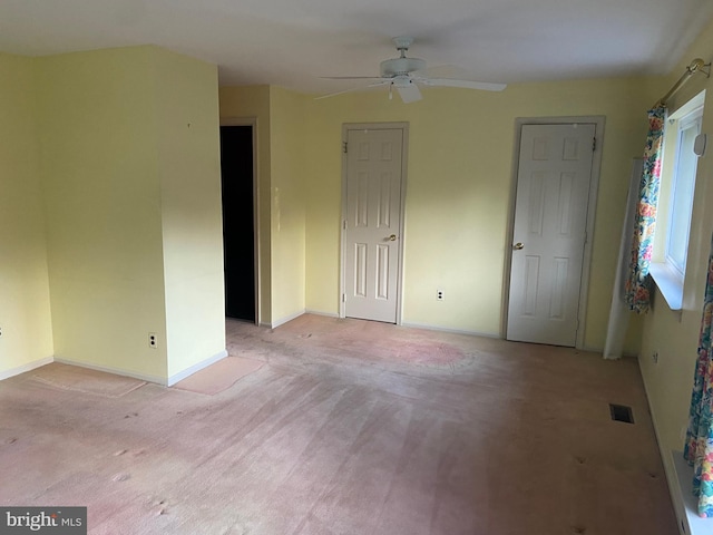 empty room with ceiling fan and light colored carpet