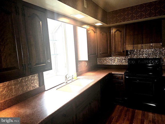 kitchen featuring tasteful backsplash, dark brown cabinets, dark wood-type flooring, sink, and black electric range