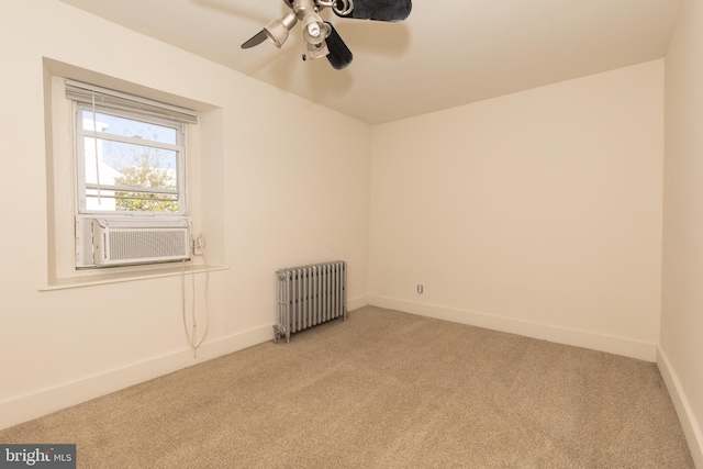 spare room with cooling unit, radiator heating unit, ceiling fan, and carpet floors