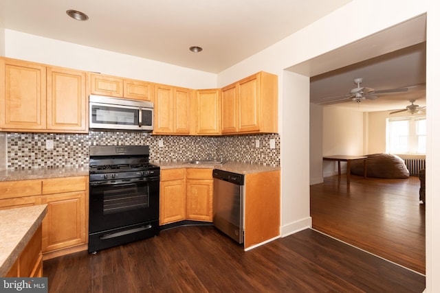 kitchen with appliances with stainless steel finishes, sink, backsplash, ceiling fan, and dark hardwood / wood-style floors