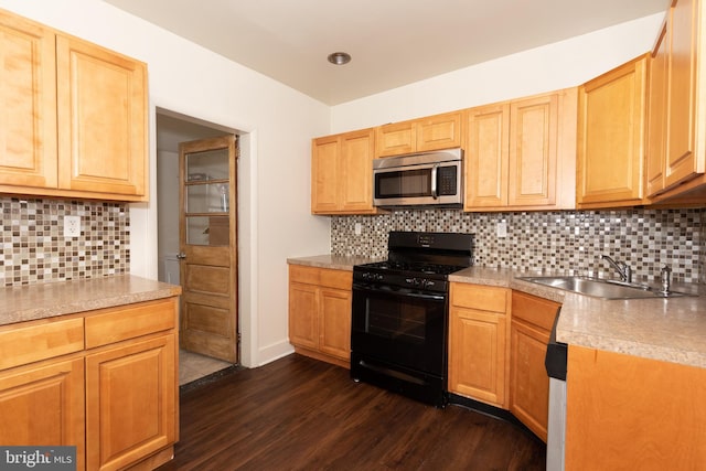 kitchen featuring black range with gas stovetop, decorative backsplash, sink, and dark wood-type flooring