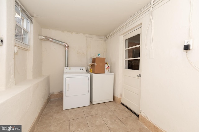 clothes washing area featuring light tile patterned flooring and separate washer and dryer