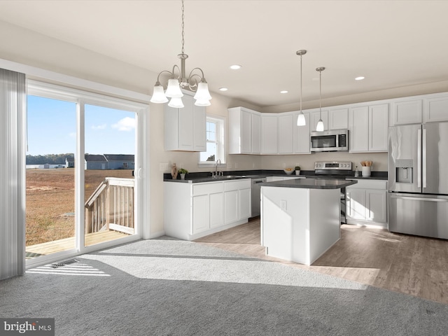 kitchen with pendant lighting, white cabinets, and stainless steel appliances