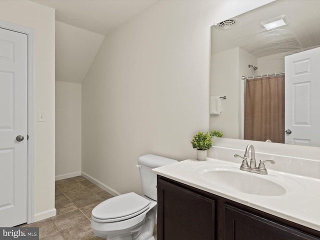 bathroom featuring vanity, lofted ceiling, toilet, and tile patterned floors