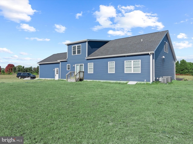 back of property with a yard and central air condition unit