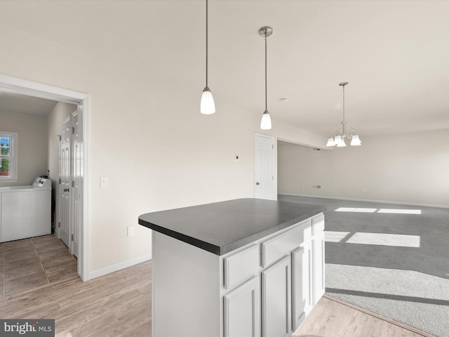 kitchen with hanging light fixtures, light hardwood / wood-style flooring, an inviting chandelier, and white cabinets