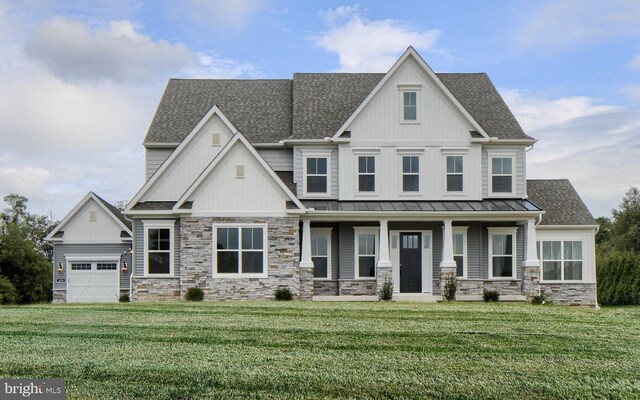 craftsman-style home with a front lawn, covered porch, and a garage