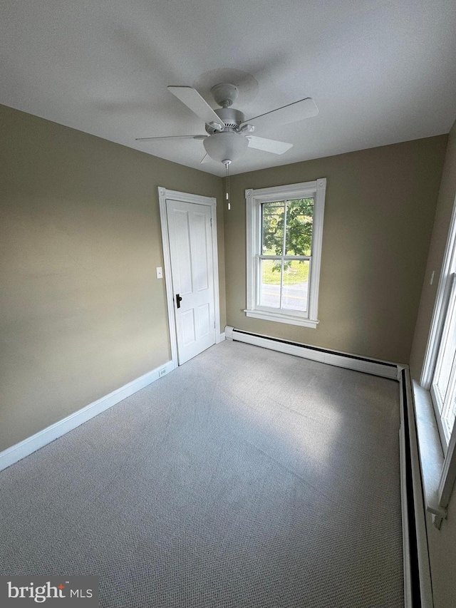 carpeted empty room featuring ceiling fan and a baseboard radiator