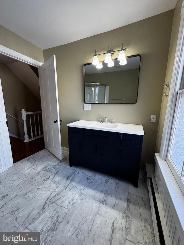 bathroom featuring vanity, hardwood / wood-style floors, vaulted ceiling, and radiator