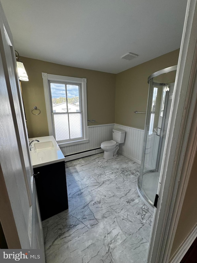 bathroom featuring vanity, walk in shower, toilet, and baseboard heating