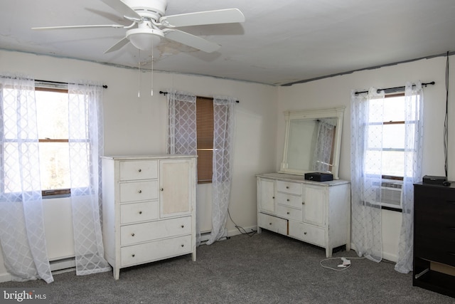 unfurnished bedroom featuring cooling unit, a baseboard heating unit, dark carpet, and ceiling fan