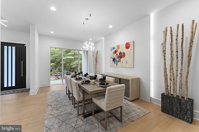 dining space featuring an inviting chandelier and light wood-type flooring