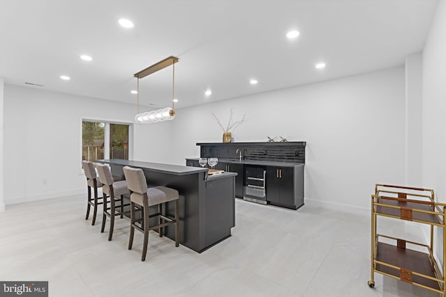 kitchen featuring sink, a center island, pendant lighting, and a kitchen breakfast bar