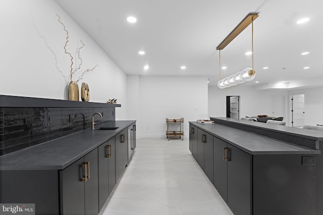 kitchen featuring tasteful backsplash, sink, and hanging light fixtures