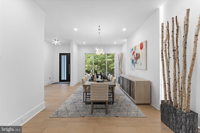 dining area with a notable chandelier and light wood-type flooring