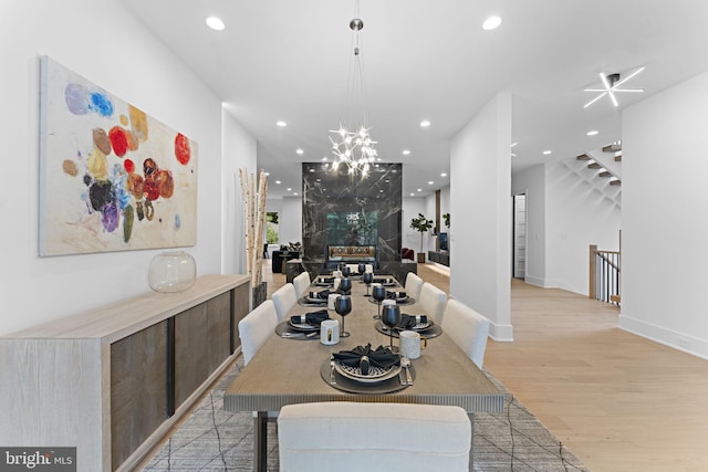 dining space with a notable chandelier and light wood-type flooring