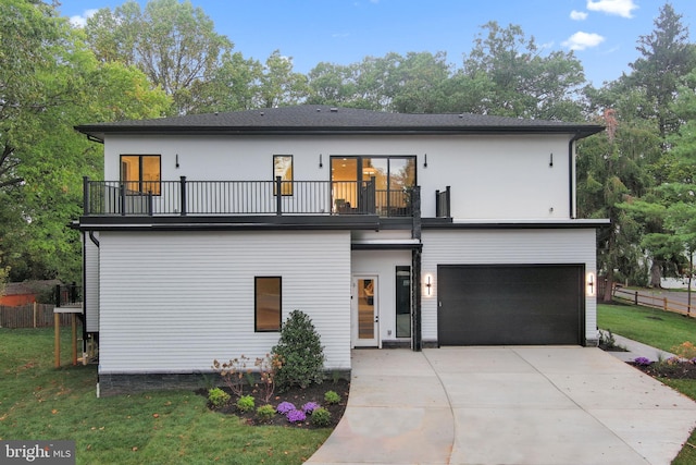 view of front of property with a front yard, a garage, and a balcony