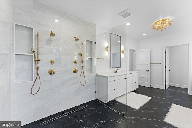 bathroom with vanity and a tile shower