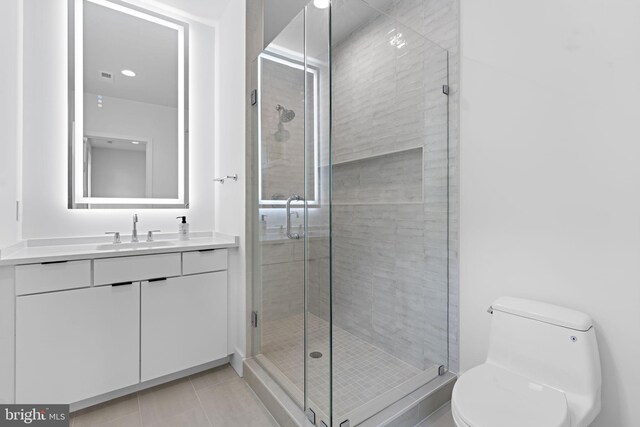 bathroom with vanity, tile patterned floors, toilet, and walk in shower