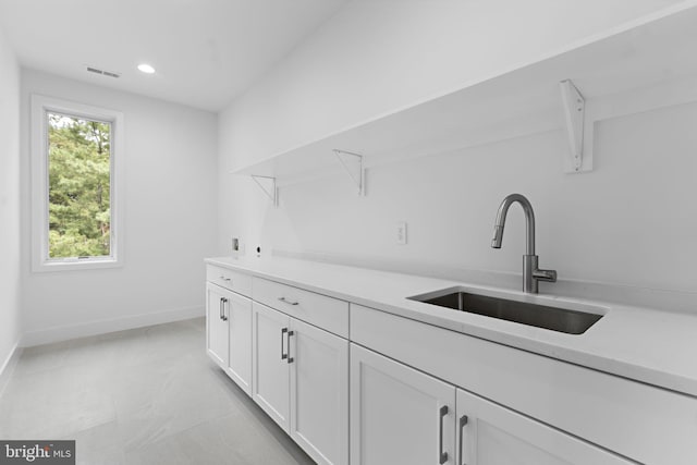 interior space featuring white cabinetry and sink